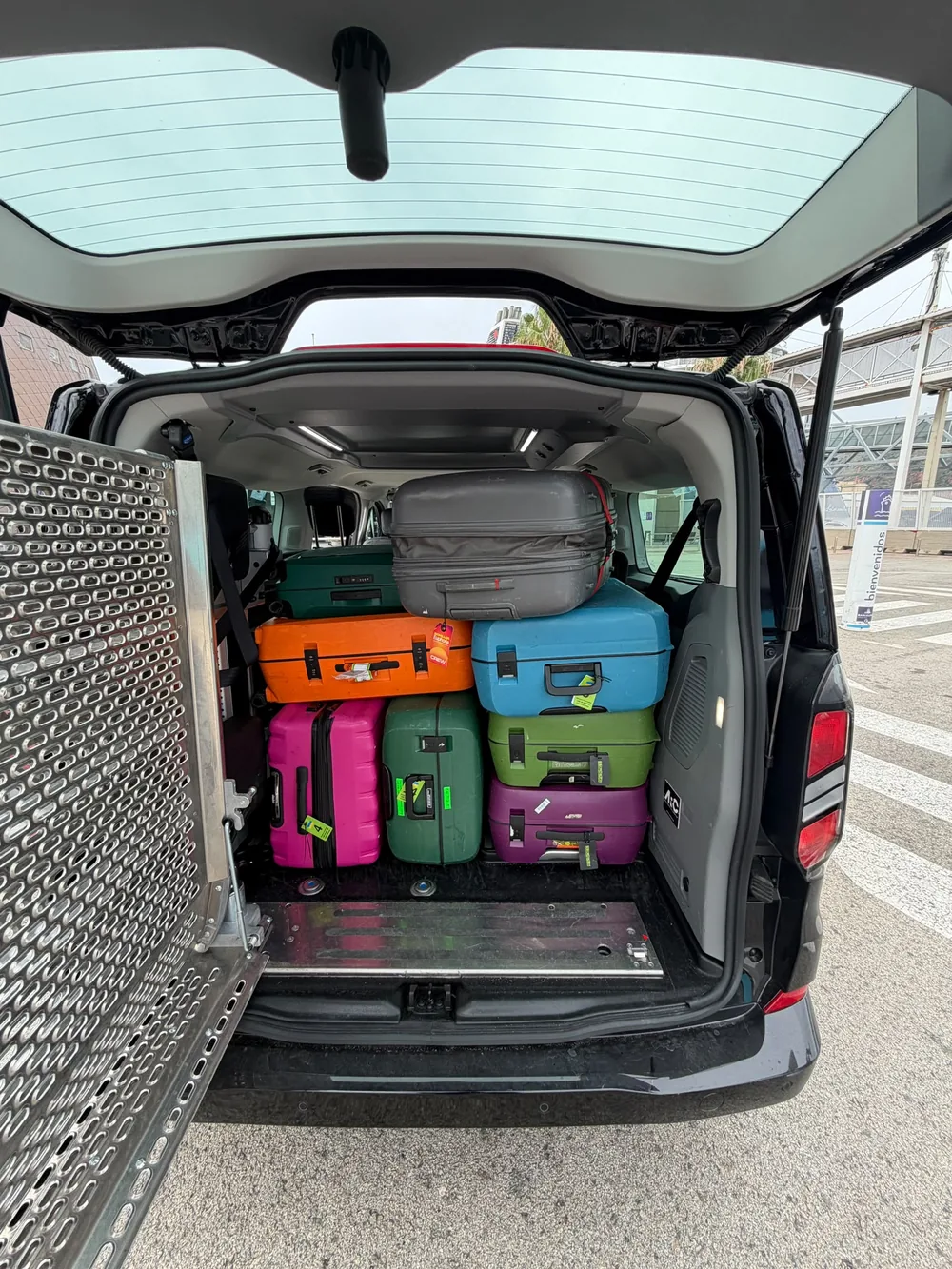 Suitcases packed in the rear luggage compartment of a transfer vehicle